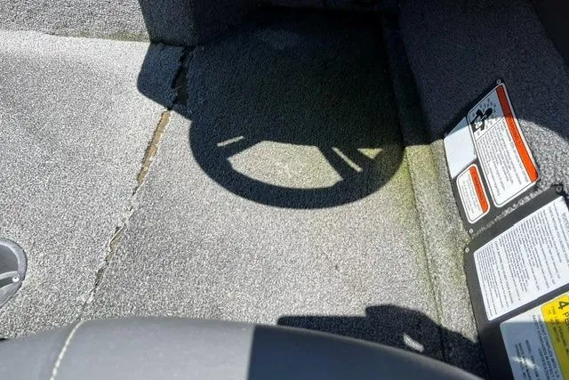 Slide: The Image of A shadow of a steering wheel on a gray carpeted floor in a boat. - 7