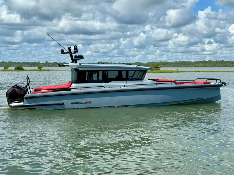 Slide: The Image of 2023 Axopar Shadow 900XC boat on calm water under cloudy sky. - 0