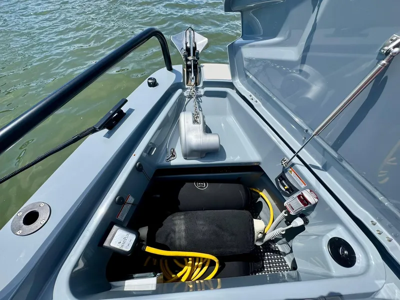 Slide: The Image of 2023 Axopar Shadow 900XC anchor compartment with equipment and storage. - 10