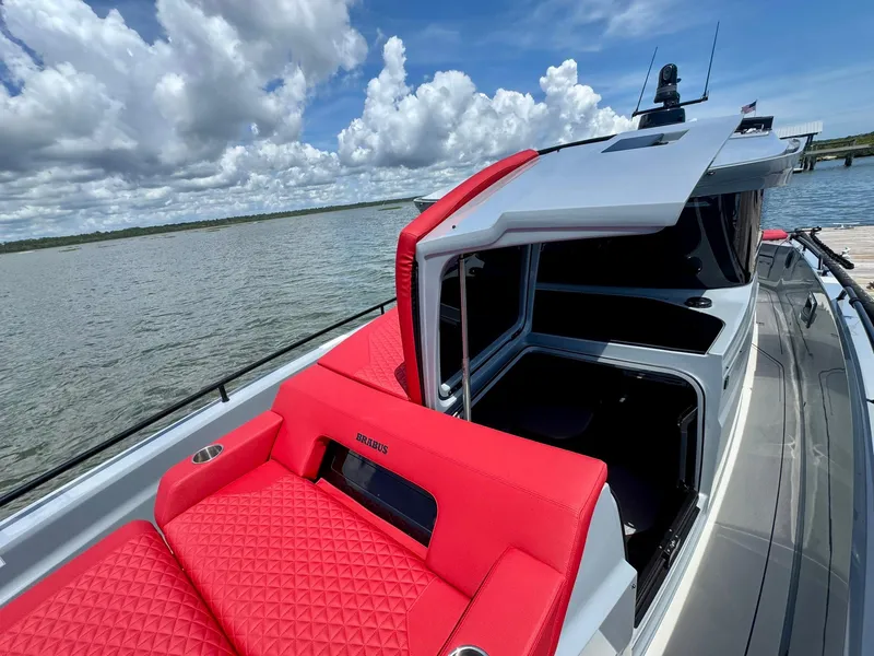 Slide: The Image of 2023 Axopar Shadow 900XC boat with red seating, docked on a sunny day. - 11