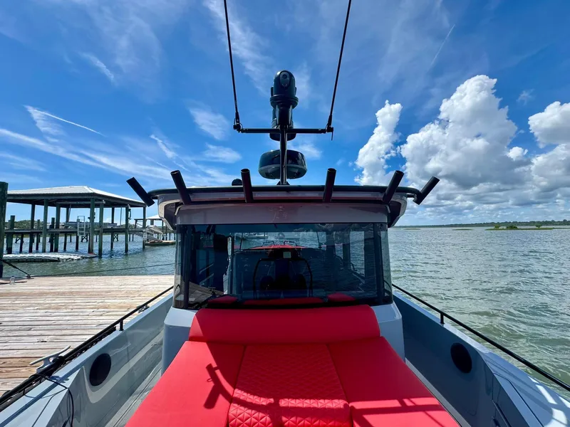 Slide: The Image of 2023 Axopar Shadow 900XC boat docked by the water under a clear blue sky. - 14