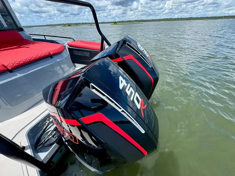 Slide: The Image of 2023 Axopar Shadow 900XC boat with dual outboard engines on a calm lake. - 17