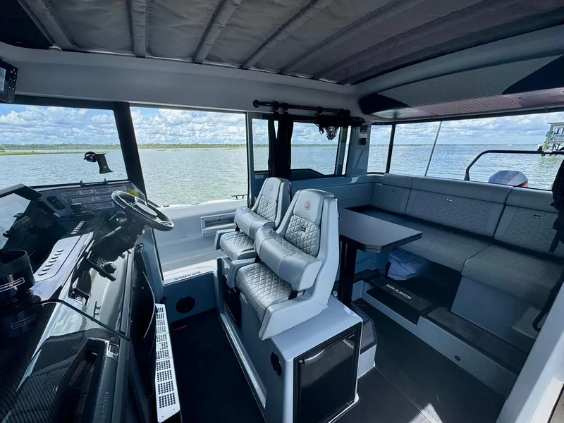 Slide: The Image of 2023 Axopar Shadow 900XC interior with modern seating and panoramic windows on the water. - 19
