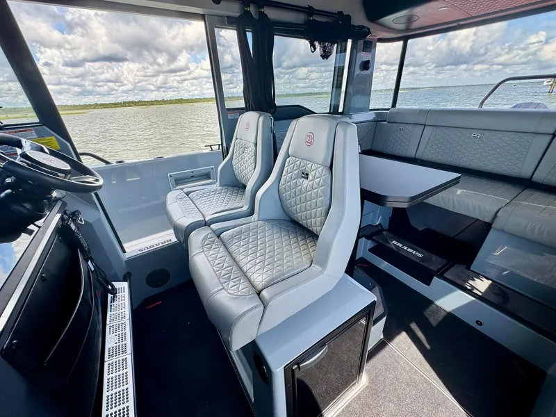 Slide: The Image of 2023 Axopar Shadow 900XC interior with luxurious seating and scenic water view. - 20