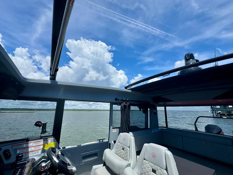 Slide: The Image of 2023 Axopar Shadow 900XC boat interior with panoramic water view and blue sky. - 21