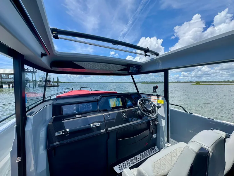 Slide: The Image of 2023 Axopar Shadow 900XC boat interior with panoramic views and modern dashboard. - 23