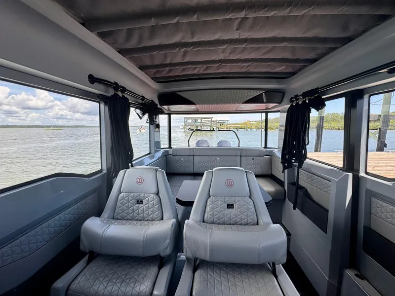 Slide: The Image of Interior of 2023 Axopar Shadow 900XC boat with luxurious seating and panoramic windows. - 24
