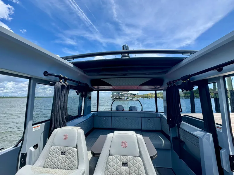 Slide: The Image of 2023 Axopar Shadow 900XC interior with luxurious seating and panoramic water view. - 25