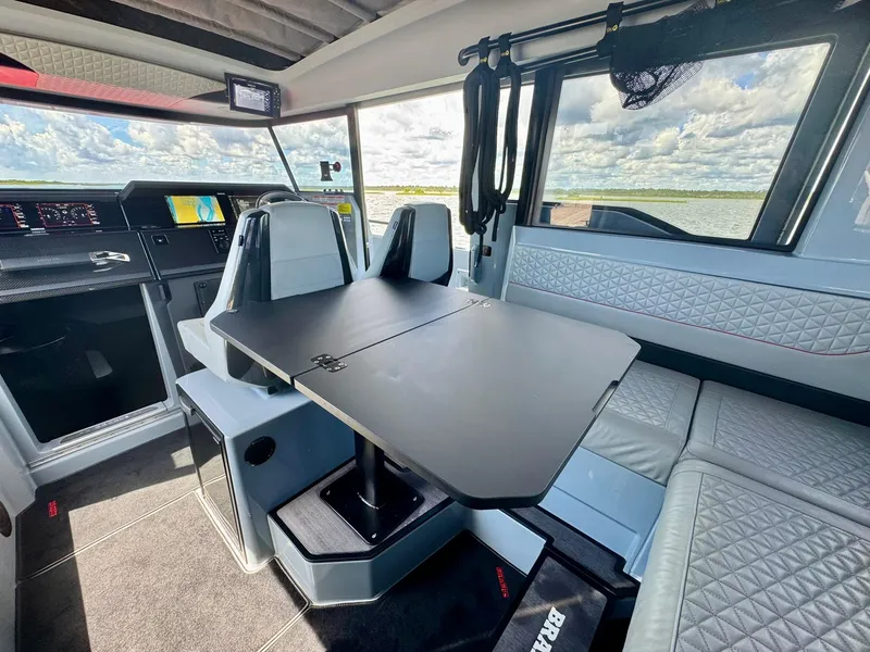 Slide: The Image of Interior of 2023 Axopar Shadow 900XC boat with modern seating and table setup. - 26