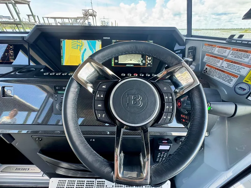 Slide: The Image of Steering wheel and dashboard of 2023 Axopar Shadow 900XC boat, featuring navigation displays. - 30