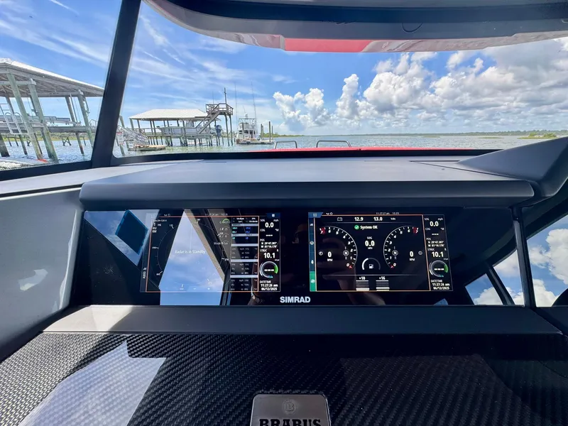 Slide: The Image of Dashboard view of 2023 Axopar Shadow 900XC boat with digital displays and scenic water background. - 32