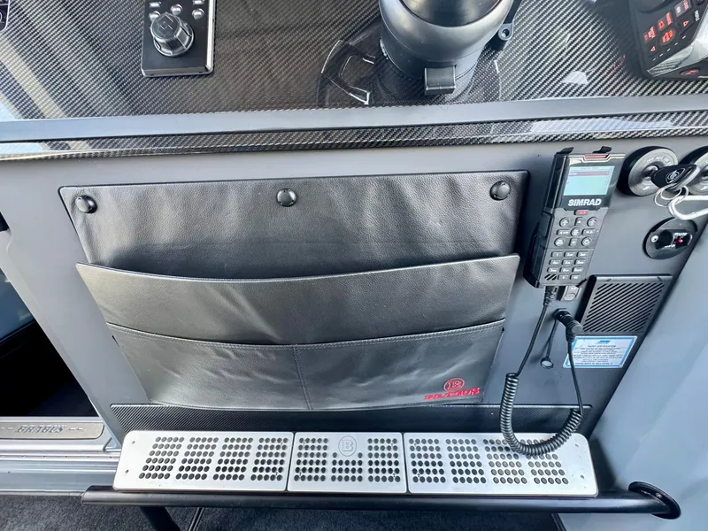 Slide: The Image of Control panel of 2023 Axopar Shadow 900XC with storage pockets and communication device. - 36