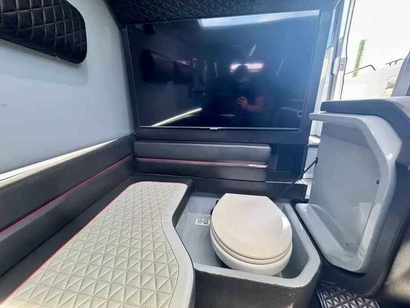 Slide: The Image of 2023 Axopar Shadow 900XC interior with seating, TV, and storage compartment. - 42