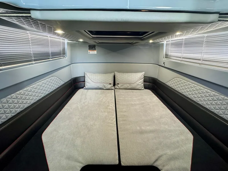 Slide: The Image of 2023 Axopar Shadow 900XC cabin interior with modern bedding and sleek design. - 44