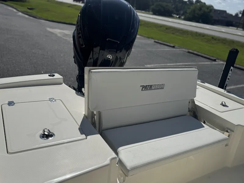Slide: The Image of 2025 Pathfinder 2200 TRS boat interior with seating and motor, parked outdoors. - 15