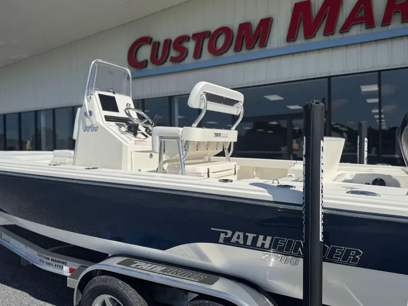 Slide: The Image of 2025 Pathfinder 2200 TRS boat on trailer outside Custom Marine store. - 3