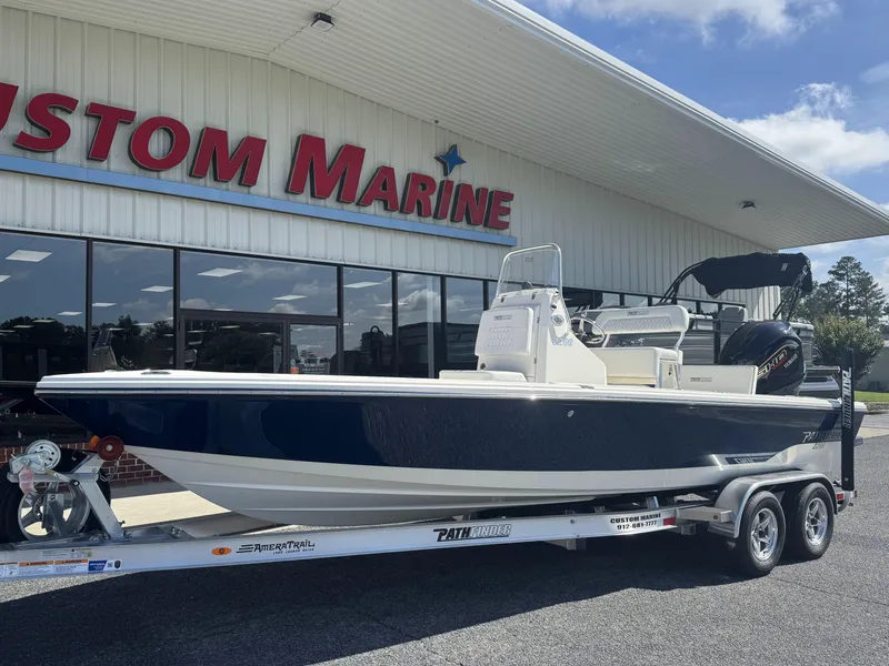 Slide: The Image of 2025 Pathfinder 2200 TRS boat on trailer outside Custom Marine dealership. - 7