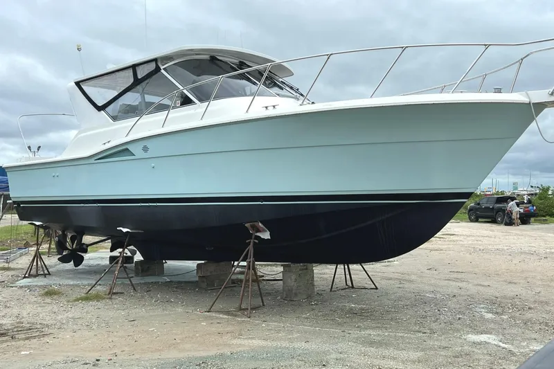 Slide: The Image of 1996 Hatteras 39 Sport Express boat on stands, displayed outdoors under cloudy skies. - 3