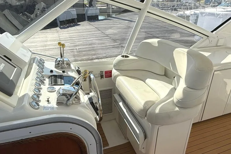 Slide: The Image of 1996 Hatteras 39 Sport Express helm with white leather seating and control panel. - 7