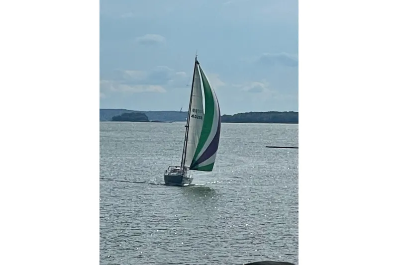 Slide: The Image of Sailboat Sabre 402 from 2000 with colorful sail on calm water. - 21