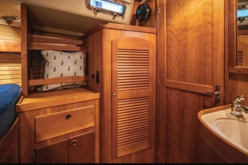 Slide: The Image of Interior of 2000 Sabre 402 yacht with wooden cabinetry and cozy sleeping area. - 4