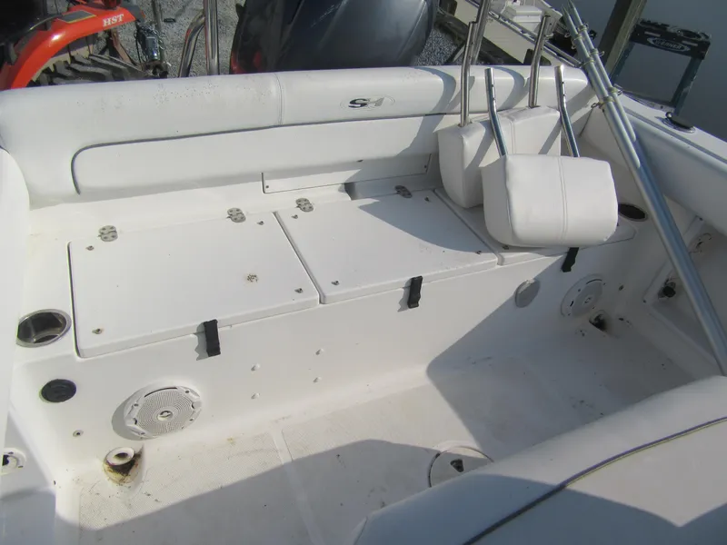 Slide: The Image of 2014 Sea Hunt Ultra 234 boat interior with white seating and storage compartments. - 2