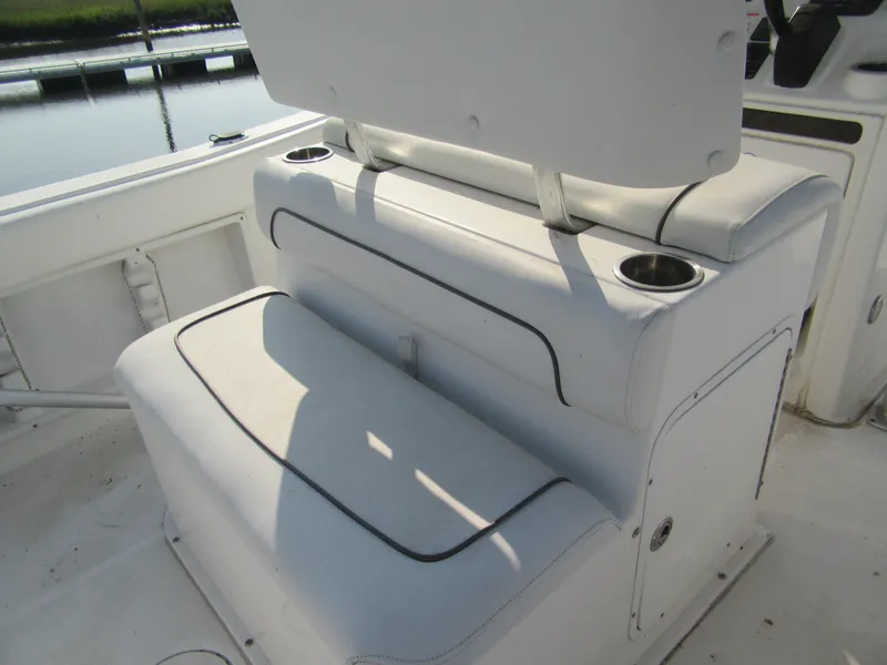 Slide: The Image of 2014 Sea Hunt Ultra 234 boat seating with cup holders, docked by the water. - 3