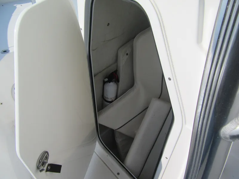 Slide: The Image of Storage compartment inside 2014 Sea Hunt Ultra 234 boat, featuring seating and safety equipment. - 6