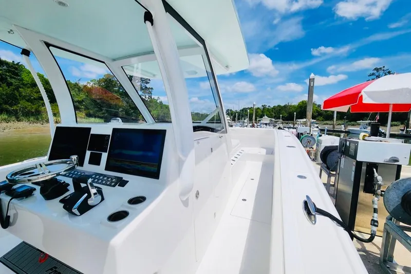 Slide: The Image of 2024 Front Runner 37 Catamaran at dock, featuring modern helm and controls under blue sky. - 5