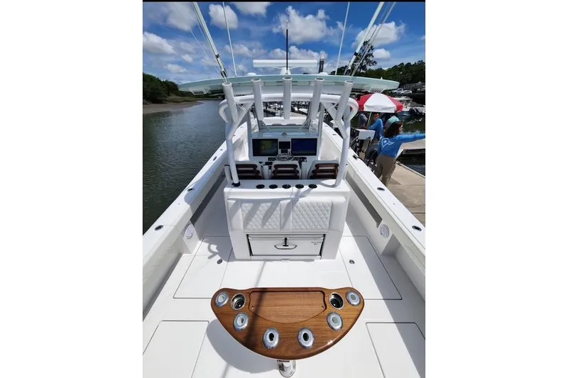 Slide: The Image of 2024 Front Runner 37 Catamaran cockpit with modern controls and seating, docked by a river. - 7