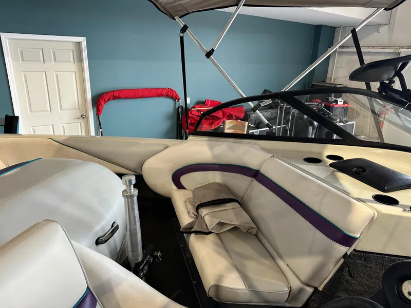 Slide: The Image of Interior of a 1995 Tigé 2002 FSLM COMP boat with beige and purple seating. - 10