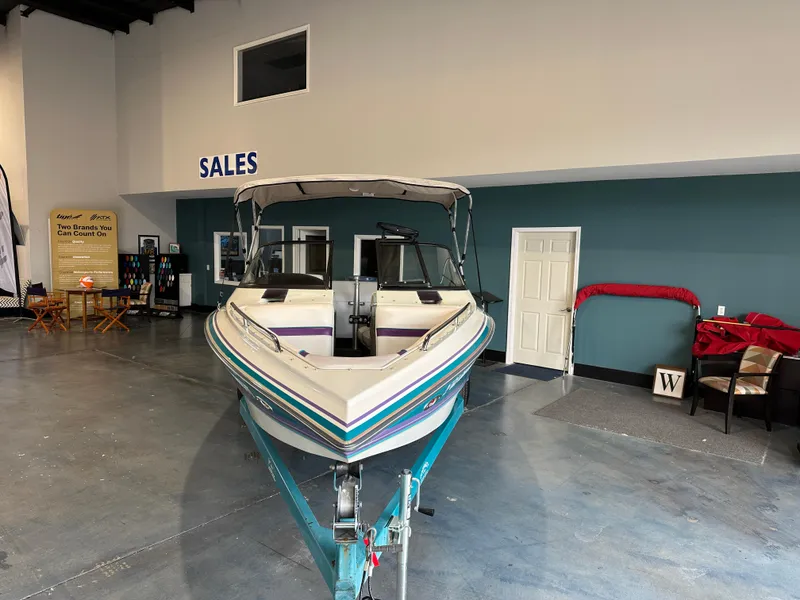 Slide: The Image of 1995 Tigé 2002 FSLM COMP boat displayed in a showroom with sales signage. - 3