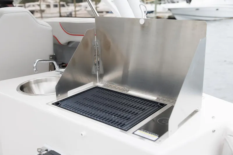 Slide: The Image of Outdoor grill and sink on 2026 Solara S-250 DC boat, docked by the water. - 21
