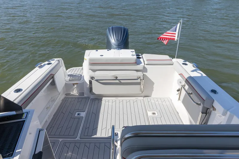 Slide: The Image of 2026 Solara S-250 DC boat deck with seating, American flag, and outboard motor on water. - 27