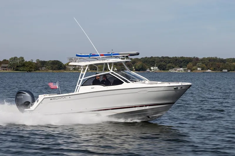 Slide: The Image of 2026 Solara S-250 DC boat cruising on a lake with American flag. - 4