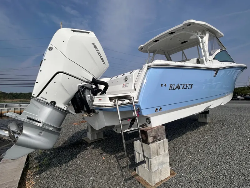 The Image of 2024 Blackfin 302DC boat with Mercury engine on display, elevated on blocks. - 1
