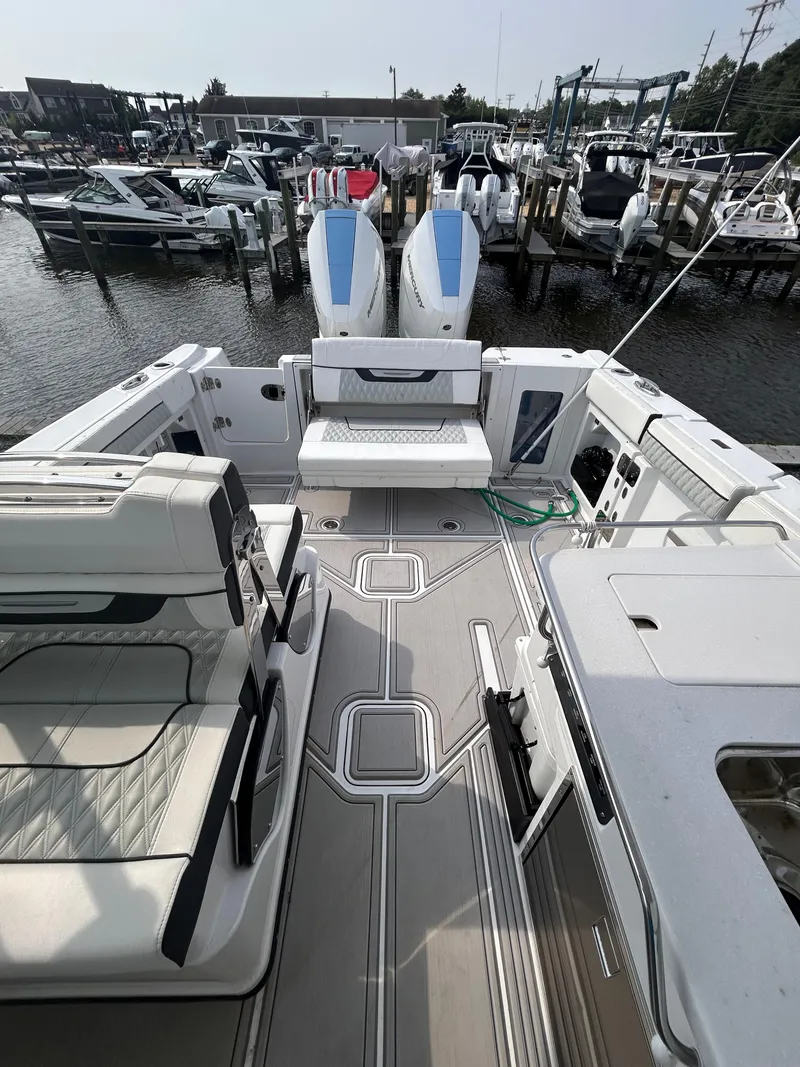 Slide: The Image of 2024 Blackfin 302DC boat docked at marina with twin engines and spacious deck. - 14