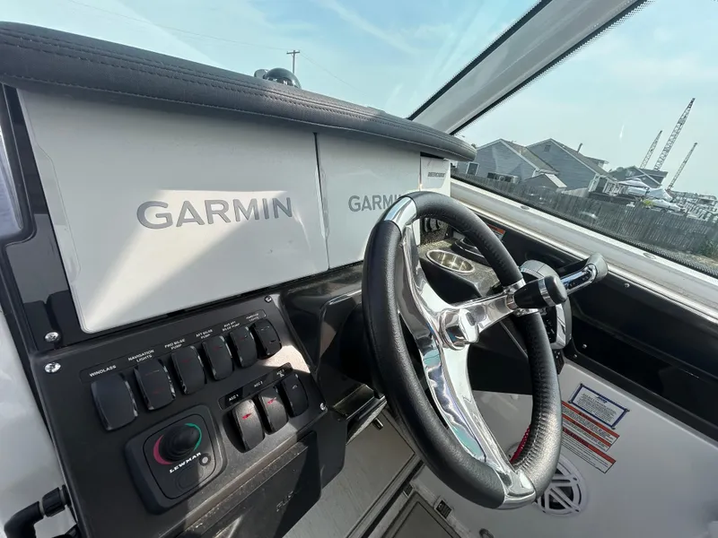 Slide: The Image of 2024 Blackfin 302DC boat dashboard with Garmin navigation system and steering wheel. - 16
