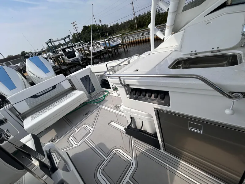 Slide: The Image of 2024 Blackfin 302DC boat interior with seating, sink, and storage, docked at marina. - 17