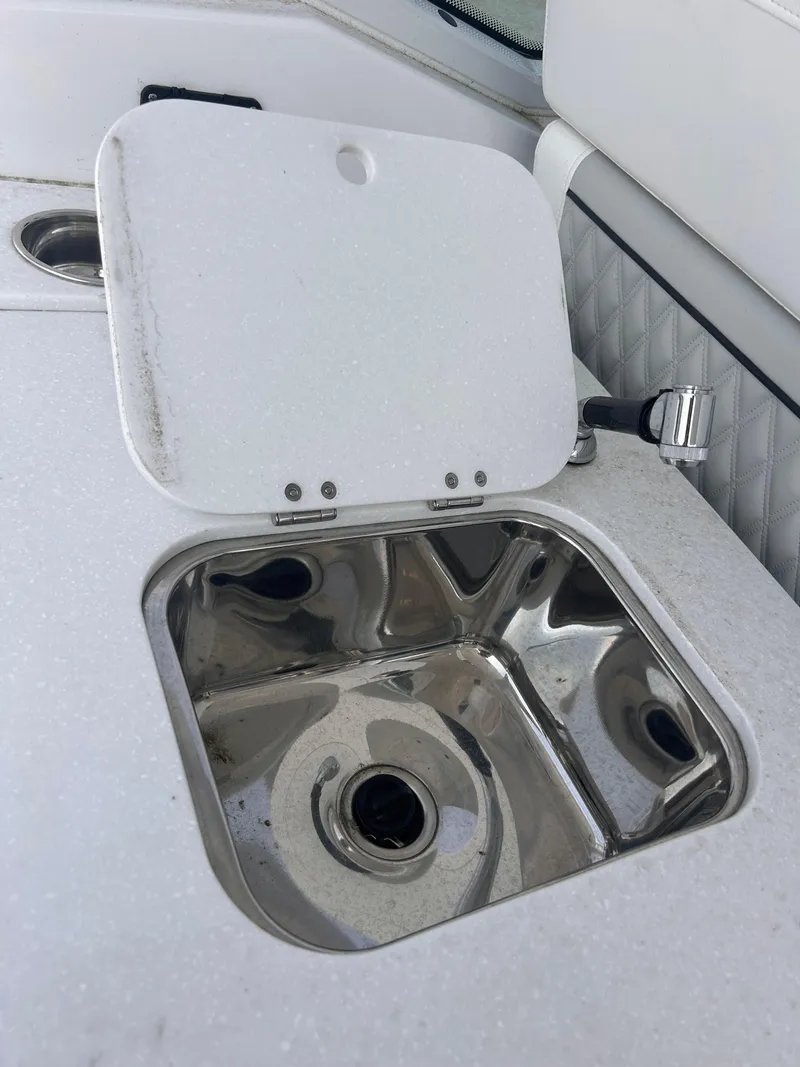 Slide: The Image of 2024 Blackfin 302DC boat sink with stainless steel basin and white cover. - 19