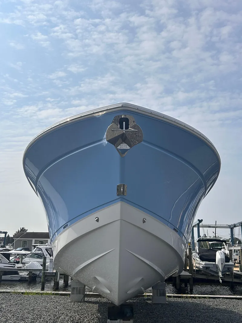 Slide: The Image of 2024 Blackfin 302DC boat, front view, displayed outdoors under a cloudy sky. - 3