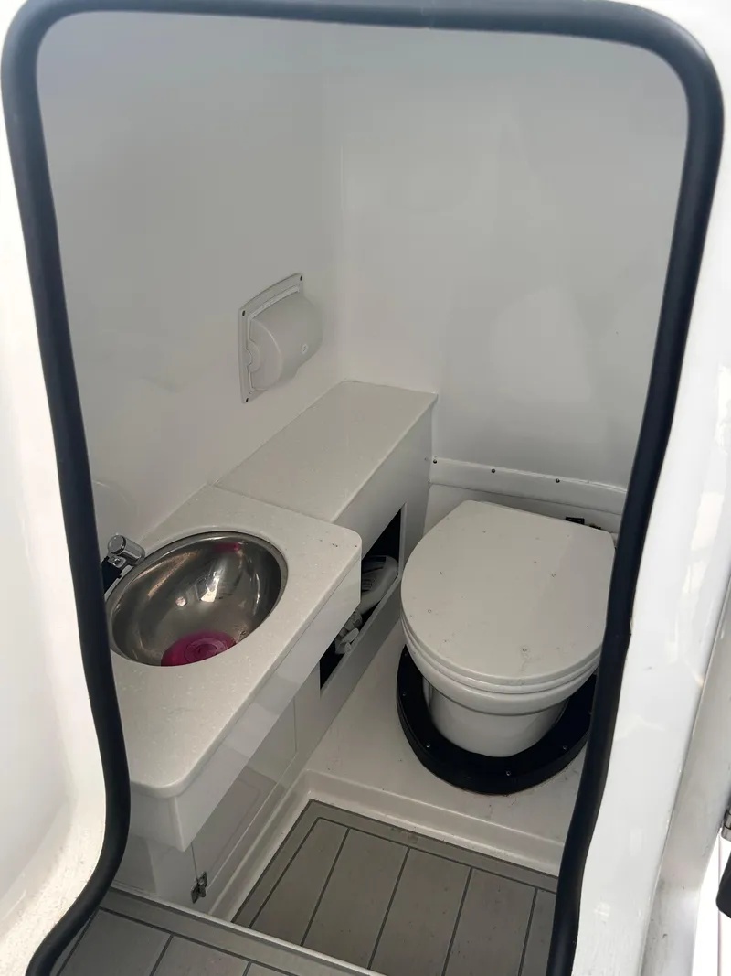 Slide: The Image of 2024 Blackfin 302DC boat interior bathroom with sink and toilet. - 6