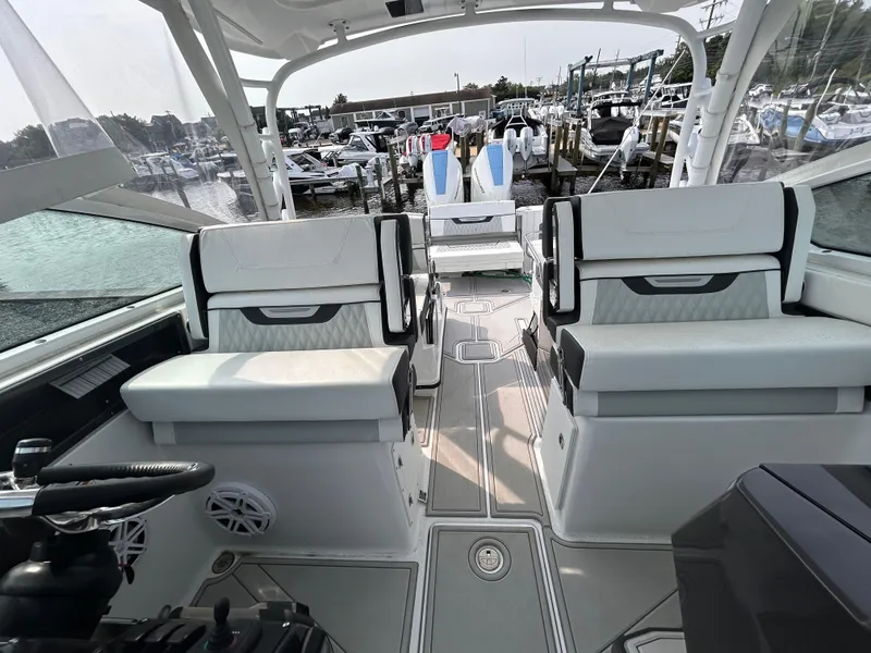 Slide: The Image of 2024 Blackfin 302DC boat interior with white seating, docked at a marina. - 8