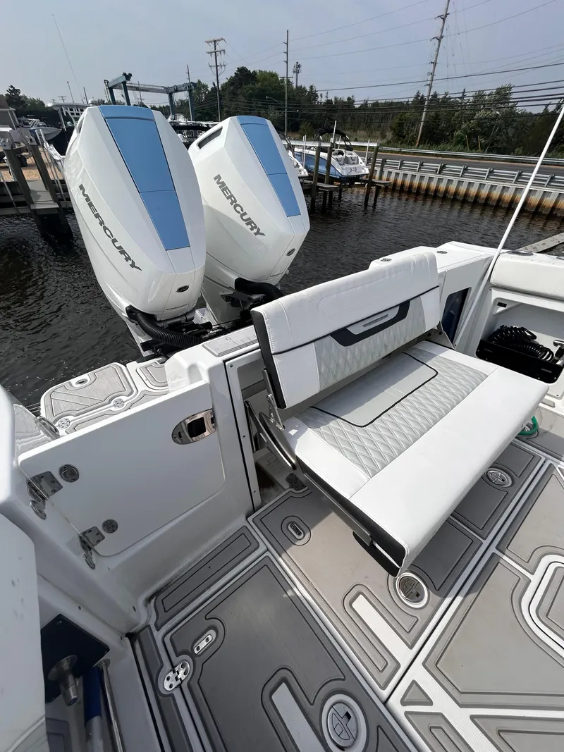 Slide: The Image of 2024 Blackfin 302DC boat with twin Mercury outboard engines at a dock. - 9