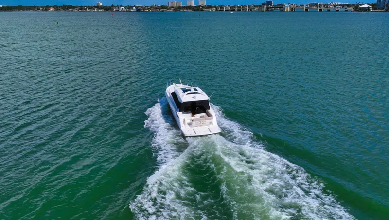 Slide: The Image of 2016 Sea Ray 470 Sundancer cruising on open water with city skyline in background. - 11