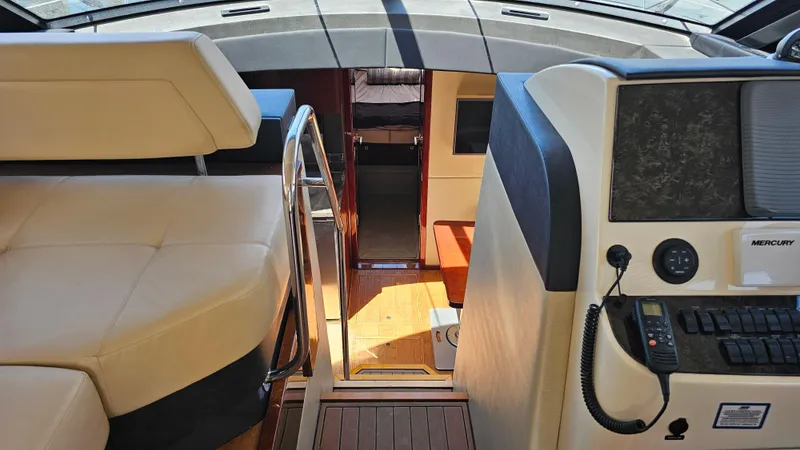 Slide: The Image of Interior view of 2016 Sea Ray 470 Sundancer yacht, featuring helm and seating area. - 17