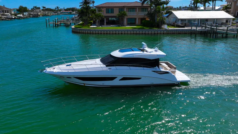 Slide: The Image of 2016 Sea Ray 470 Sundancer yacht cruising in a scenic waterfront setting. - 2