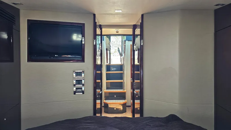 Slide: The Image of Interior of 2016 Sea Ray 470 Sundancer yacht, featuring a modern cabin with a TV and stairs. - 23