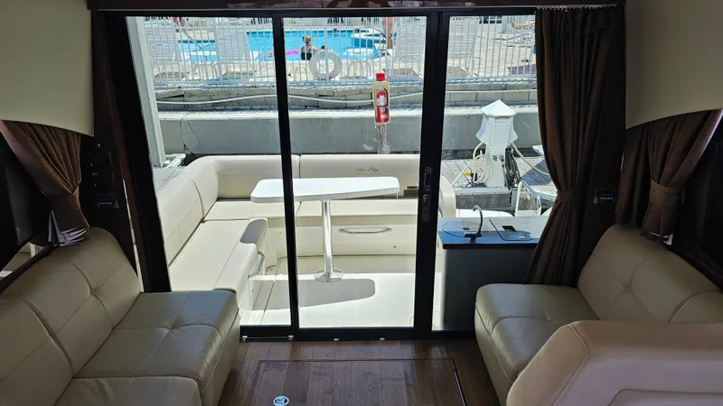 Slide: The Image of Interior view of 2016 Sea Ray 470 Sundancer yacht with beige seating and glass doors. - 27