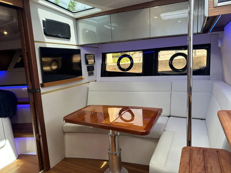 Slide: The Image of Interior of 2022 Boston Whaler 405 Conquest with white seating and wooden table. - 10